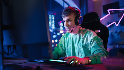 Gaming at Home: Portrait of a Gamer Wearing Headphones and Playing Online Game on Personal...