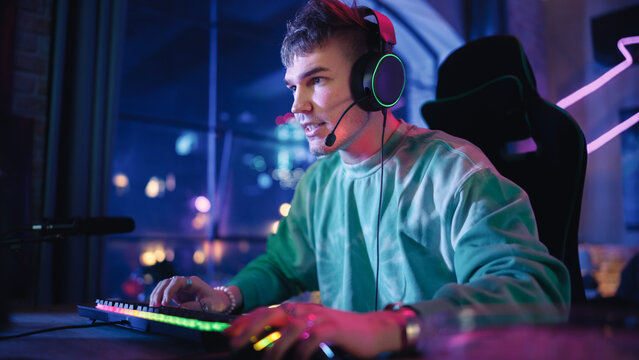 Gaming at Home: Gamer Playing Online Video Game on Computer. Close Up Portrait of Stylish Male in Headphones Enjoying Leisure Time, Talking with Players on Mic. Cyber Gaming Stylish Retro Neon Room.