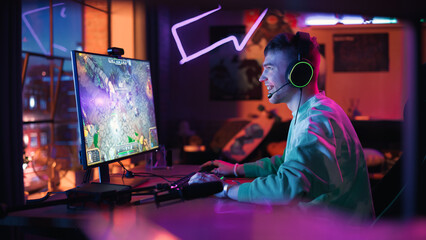 Fomous Gamer Playing and Winning in PvP RPG Strategy Video Game in Which Players Fight in a Battle Royale Tournament on Personal Computer. Stylish Man Celebrating Victory in Cozy Room at Home.