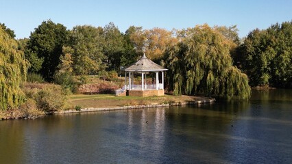 Aerial shot over a small bandstand near a lake in watermead park - obrazy, fototapety, plakaty