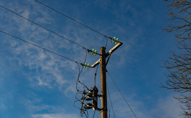 Electric wires on a pole against blue sky. Electricity supply