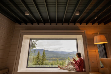 Woman rests in house with scenic views in mountains