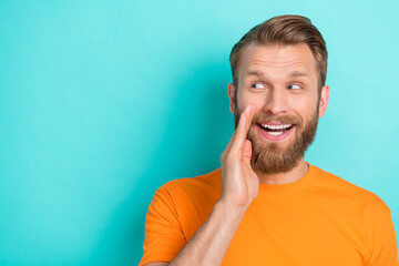 Photo of impressed brown hairdo guy look promo wear orange t-shirt isolated on turquoise color...