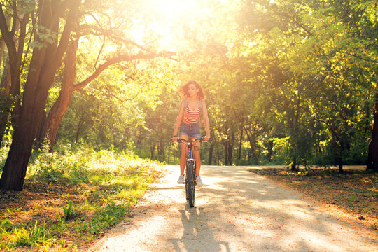 Young woman riding bicycle in the nature on a beautiful summer day