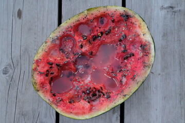 rotten watermelon, rotten berry watermelon on a wooden background