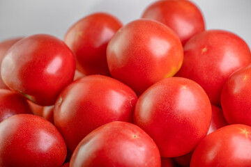 Ripe red tomatoes on white background