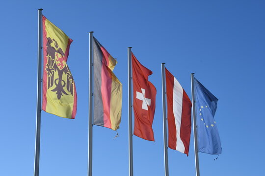 flatternde Fahnen im Gegenlicht: Deutschland, Europa Schweizer Kantone