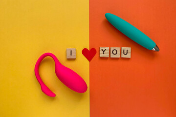 Sex toys. Pink and green vibrators on a orange background. lettering I LOVE YOU. Useful for adult,...