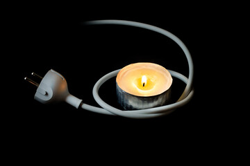 Burning candle in aluminium container and electric cable with a plug