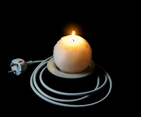Globe-shaped burning candle and electric cable with a plug as a symbol of the energy crisis