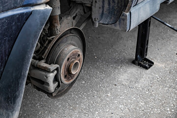 Auto mechanic changes wheel on old car. Man changes punctured tire after breakdown. Emergency roadside assistance. Automobile wheel close-up.