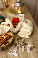 Various Christmas decorations, cup of tea or coffee, sweets, small presents, knitted blanket and candles. Selective focus.