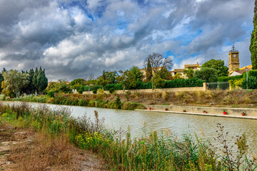 The beautiful Canal du Midi in the South of France as it passes the picturesque village of Roubia