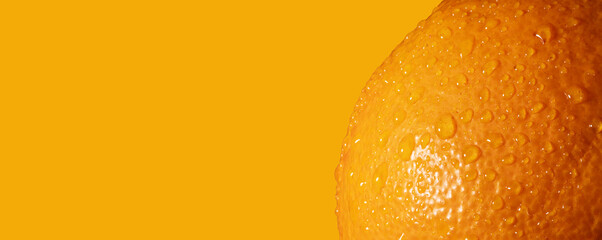 Fresh orange fruit skin close up. Ripe orange texture with water drops on orange background....