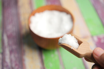 Coarse salt in a wooden spoon selective focus 