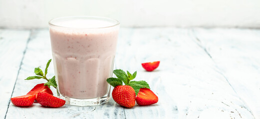 smoothie with berries. Strawberry smoothie or milkshake with berries and yogurt in glass jar on white background. Vegetarian healthy drink. Long banner format. top view