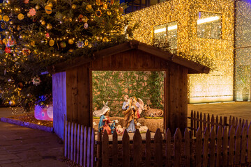 Nativity scene with christmas crib showing the holy family at traditional Christkindlmarkt near Hotel Terme, Meran(o) South Tyrol Italy - obrazy, fototapety, plakaty