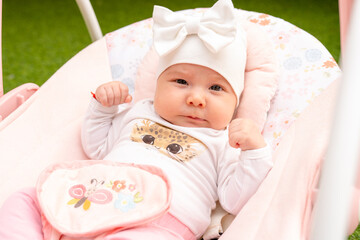 Close up Newborn baby girl sleeping in white stroller on a walk in summer park. New born child...