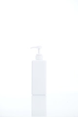 White cosmetic bottle dispenser pump with tube container from front angle isolated on white background.