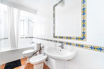 Clean bright bathroom interior with white toilet and traditional tiles. Original designed hotel...