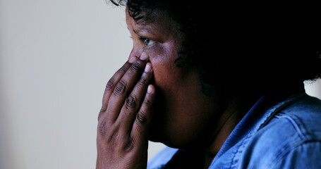 Naklejka premium Tearful black African woman wipes tears in anguish