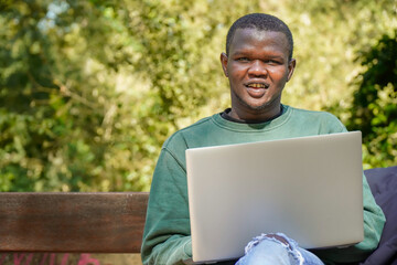 portrait of a black african boy working on his laptop. Digital nomad and migration