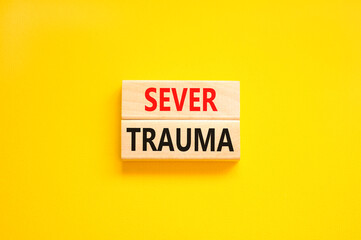 Sever trauma symbol. Concept words Sever trauma on wooden blocks. Beautiful yellow table yellow background. Psychological and sever trauma concept. Copy space.