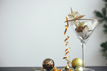 New year party creative concept. Stylish christmas glitter star in champagne glass, golden confetti...