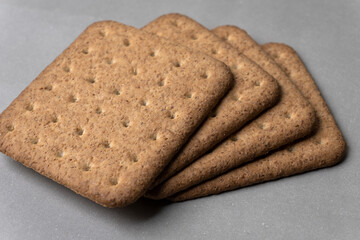 whole wheat healthy biscuits slices closeup side view  on gray background