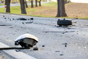 Rozrzucone elementy samochodu po wypadku drogowym na drodze.  © FotoDax