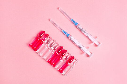 Ampoules for injections for health and beauty, B vitamins in glass , women's health on a pink background