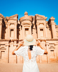 Cinematic Petra background caucasian young woman in white dress and hat enjoying Petra A'deir...