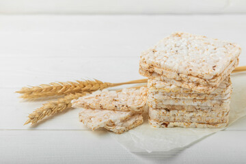 Round rice cakes and spikelets on a white wooden table. Crispbread.Puffed rice bread. diet crispy round rice cakes.Place for text. Place for copy. Healthy food. dietary product.