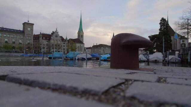 Old town of City of Z&uuml;rich with bitt and Limmat River and churches Women's Minster, St. Peter and Great Minster on a late cloudy afternoon. Movie shot November 4th, 2022, Zurich, Switzerland.