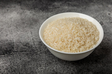 Healthy food. A bowl of steamed rice on a black marble background. Place for text, copy space. Diet porridge.