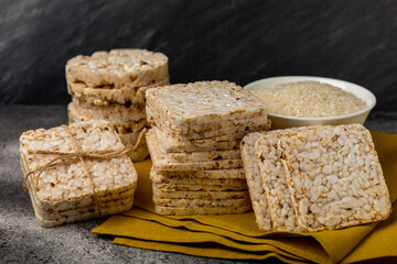 Round rice cakes and rice in a bowl on a  black table. Crispbread.Puffed rice bread. diet crispy round rice cakes.Place for text. Place for copy. Healthy food. dietary product