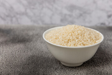 Healthy food. A bowl of steamed rice on a black marble background. Place for text, copy space. Diet porridge.