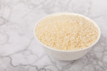 Healthy food. A bowl of steamed rice on a white marble background. Place for text, copy space. Diet porridge.