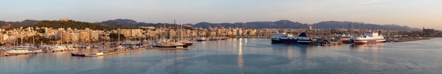 Naklejka na ściany i meble Boats in a Marina with Downtown City Buildings by Balearic Sea. Sunny Sunrise. Palma, Balearic Islands, Spain. Aerial Panoramic View from Cruise Ship.