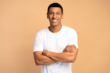 Happy successful man posing with happy confident expression, keeping arms folded