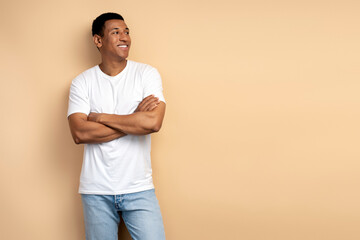 Happy successful man posing with happy confident expression, keeping arms folded