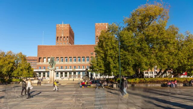 Oslo city hall (radhus, radhuset) hyper-lapse: time-lapse of the capital of Norway, featuring red brick building and two towers, on a sunny day, under clear blue sky, with people walking on the square