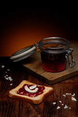 Slice of toast and strawberry jam on wooden table