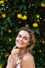 Portrait of beautiful woman with smooth skin against lemon trees