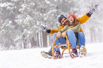 Couple having fun sledging while on winter vacation