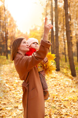  Mother and daughter having fun in autumn park. Happy family on walk. High quality photo