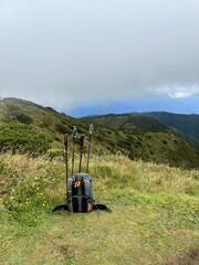 Backpack and hiking sticks on top of a mountain 