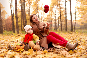  Mother and daughter having fun in autumn park. Happy family on walk. High quality photo