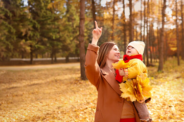  Mother and daughter having fun in autumn park. Happy family on walk. High quality photo