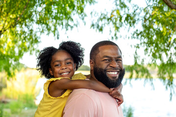 Father and daughter smiling and laughing outside.